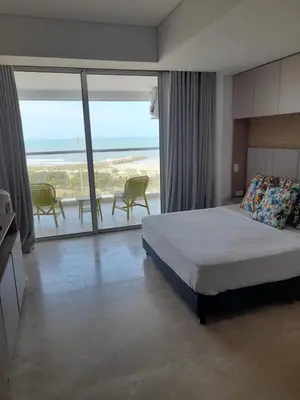 a bedroom with a bed and a view of the ocean at Cartagena Beach Resort in Cartagena de Indias