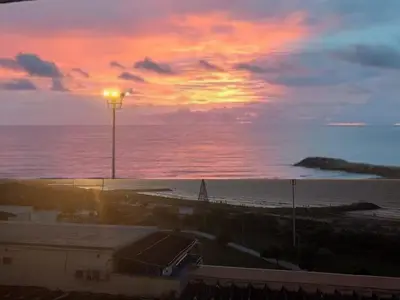 a sunset over the ocean with a street light at Cartagena Beach Resort in Cartagena de Indias