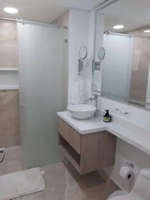 a white bathroom with a sink and a mirror at Cartagena Beach Resort in Cartagena de Indias