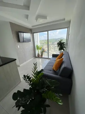a living room with a blue couch and a large window at Alina Beautiful Cartagena Apartment in Cartagena de Indias