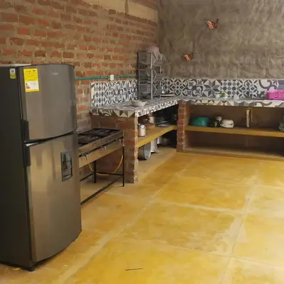 a kitchen with a stainless steel refrigerator in a room at CABAÑA el EDEN in Santa Veronica