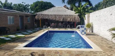 a swimming pool in a yard next to a house at CABAÑA el EDEN in Santa Veronica