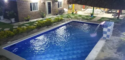 a swimming pool with a waterfall in a backyard at CABAÑA el EDEN in Santa Veronica