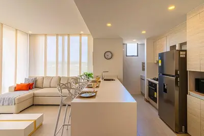 a kitchen and living room with a couch and a refrigerator at Exclusive 2BR en Morros Eos with Pool & Parking in Cartagena de Indias