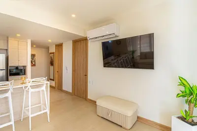 a living room and kitchen with a air conditioner on the wall at Exclusive 2BR en Morros Eos with Pool & Parking in Cartagena de Indias