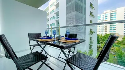 a table on a balcony with chairs and wine glasses at Comodos Aptos en Morros3 con salida directa a la playa, piscina & parking in Cartagena de Indias