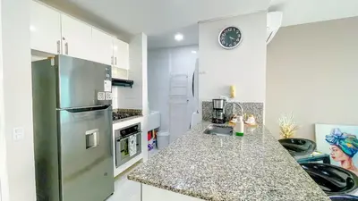 a kitchen with a stainless steel refrigerator and a counter at Comodos Aptos en Morros3 con salida directa a la playa, piscina & parking in Cartagena de Indias