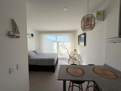 a kitchen and living room with a table and a couch at All new apartment in Santa Marta - NR Stays in Santa Marta