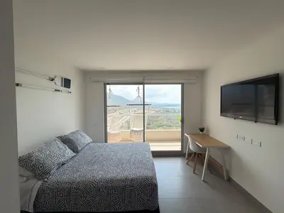 a bedroom with a bed and a flat screen tv at All new apartment in Santa Marta - NR Stays in Santa Marta