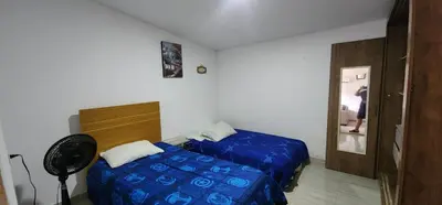 a bedroom with a blue bed and a fan at Casa playa salgar in Puerto Colombia