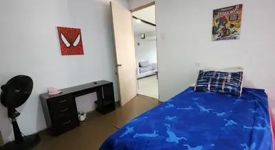 a bedroom with a blue bed and a television at Casa playa salgar in Puerto Colombia
