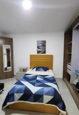 a bedroom with a bed with a blue and white comforter at Casa playa salgar in Puerto Colombia