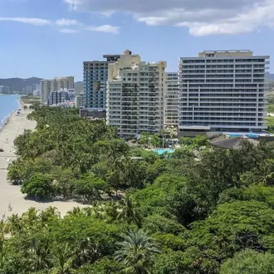 a city with tall buildings and a beach with trees at Apartaestudio con hotel y playa in Santa Marta