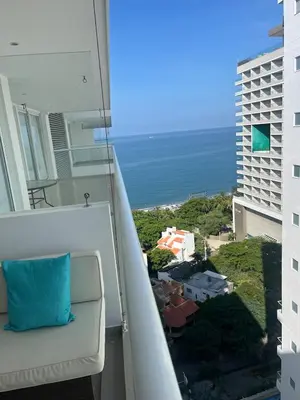 a balcony with a couch and a view of the ocean at Apartaestudio con hotel y playa in Santa Marta