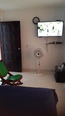 a living room with a green chair and a flat screen tv at Apartamento Sector Torices in Cartagena de Indias