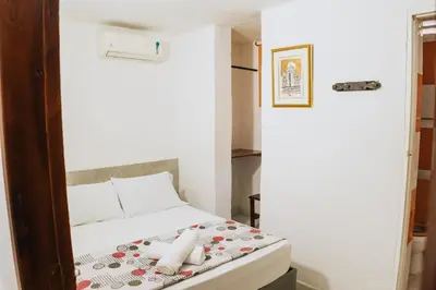 a small room with a bed and a mirror at Hotel Ibatama in Cartagena de Indias