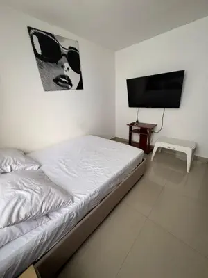 a bedroom with a bed and a flat screen tv at Acogedor espacio familiar in Cartagena de Indias