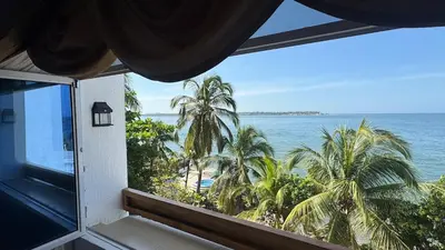 a room with a view of the ocean and palm trees at Acogedor espacio familiar in Cartagena de Indias