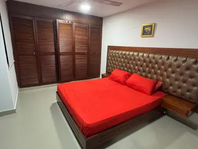 a bedroom with a red bed with a brown headboard at Acogedor espacio familiar in Cartagena de Indias