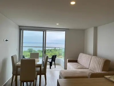 a living room with a couch and a table with chairs at Apartamento en Cielo Mar Cartagena in Cartagena de Indias