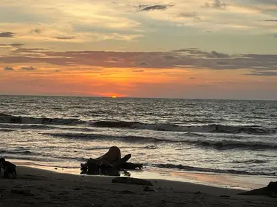 a sunset on the beach with the ocean at Mi refugio in Moñitos