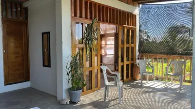 a porch with two chairs and a door with a plant at Mi refugio in Moñitos