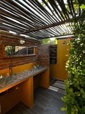 a bathroom with two sinks and a brick wall at Guacamaya Kite Lodges in Salina de Rey