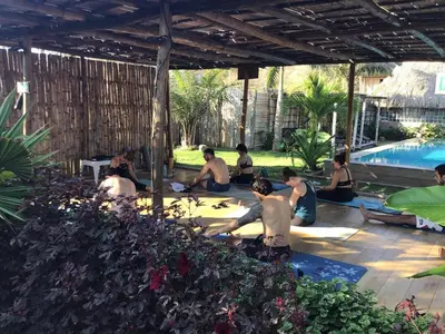 a group of people sitting around a swimming pool at Guacamaya Kite Lodges in Salina de Rey