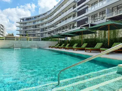 a swimming pool with chairs and an apartment building at Magnificent Apartment - Beach - Jacuzzis! in Cartagena de Indias