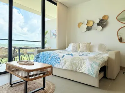 a bedroom with a bed and a table and a balcony at Magnificent Apartment - Beach - Jacuzzis! in Cartagena de Indias