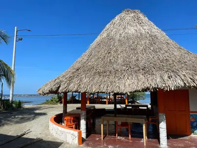 a hut with a table and chairs on the beach at Habitacion Ely Johana in Coveñas
