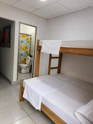 a bedroom with a bunk bed and a bathroom with a toilet at Habitacion Ely Johana in Coveñas