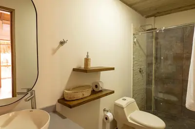 a bathroom with a toilet and a glass shower at Casa Barú in Baru