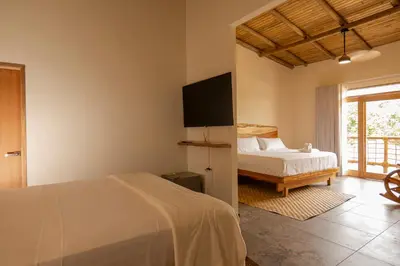 a bedroom with a bed and a tv on the wall at Casa Barú in Baru