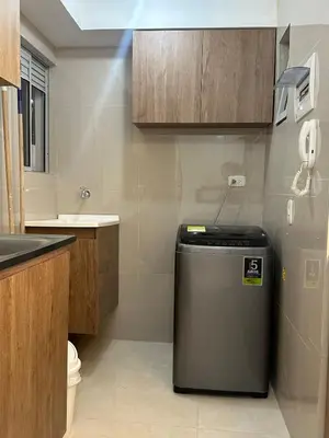 a small kitchen with a trash can in the corner at Comfortable and nice apartment in Barranquilla