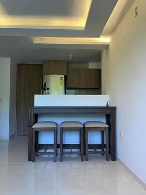 a kitchen with a counter with two stools around it at Comfortable and nice apartment in Barranquilla