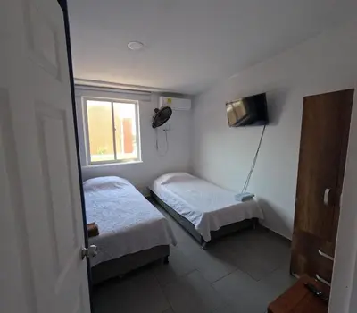 a small room with two beds and a window at Cartagena loft apartment near historic center in Cartagena de Indias