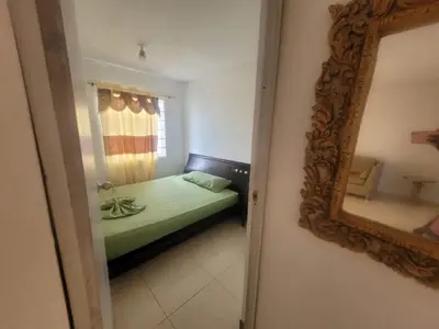 a bedroom with a green bed and a mirror at Romero Cartagena in Cartagena de Indias