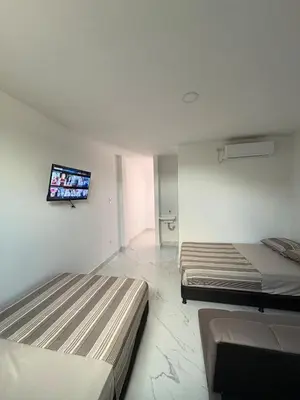 two beds in a room with a tv on the wall at Maru apartamentos #5 in Cartagena de Indias