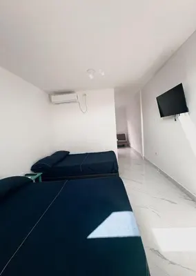 a bedroom with two beds and a tv on the wall at Maru apartamentos #6 in Cartagena de Indias