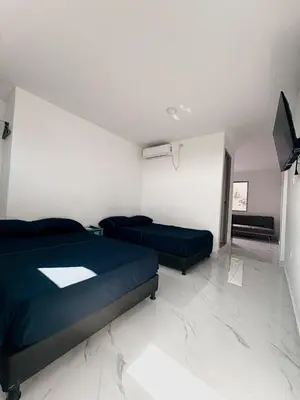 a bedroom with two beds and a flat screen tv at Maru apartamentos #6 in Cartagena de Indias