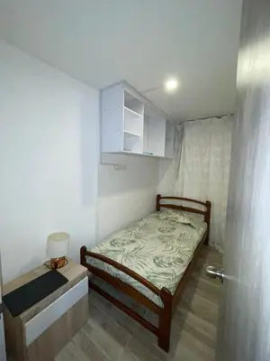 a small bedroom with a bed and a small cabinet at Exclusivo apartamento en ciudad Mallorquin in Barranquilla