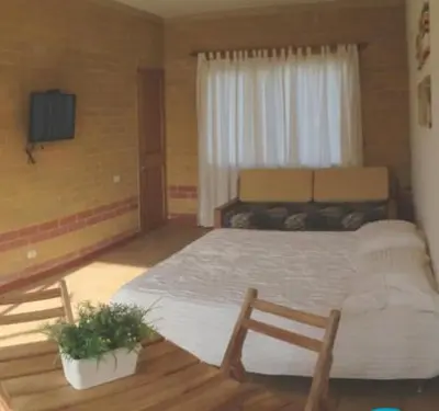 a bedroom with a large bed and a television at Apartamentos frente al Mary Tolu - Coveñas in San Silvestre