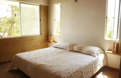 a bedroom with a bed and two windows at Apartamentos frente al Mary Tolu - Coveñas in San Silvestre