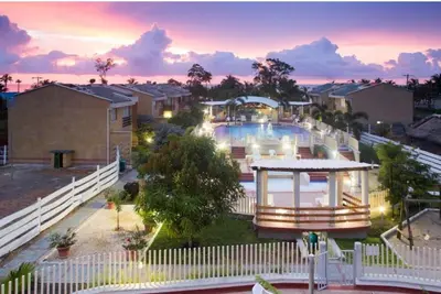 a house with a swimming pool at dusk at Apartamentos frente al Mary Tolu - Coveñas in San Silvestre
