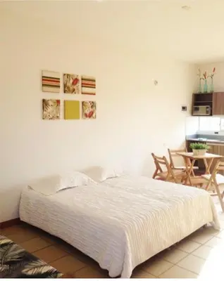 a bedroom with a white bed and a table at Apartamentos frente al Mary Tolu - Coveñas in San Silvestre