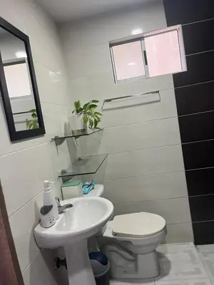 a bathroom with a white toilet and a sink at Alameda del rio Turpial in Barranquilla