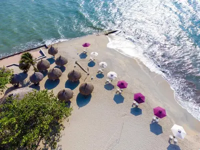 an overhead view of a beach with umbrellas and the ocean at Hotel Santorini Casablanca Resort in Santa Marta