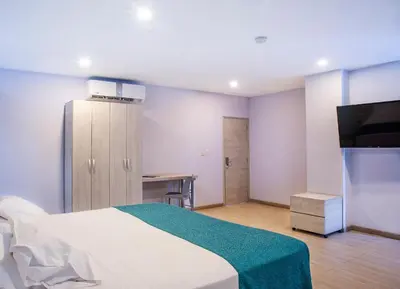 a bedroom with a white bed and a television at Hotel Santorini Casablanca Resort in Santa Marta