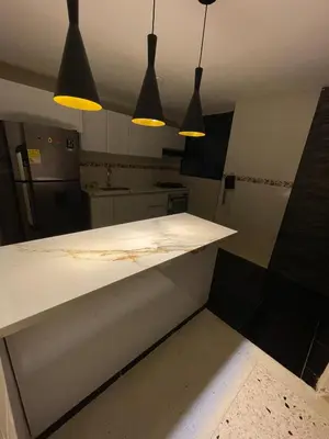 a kitchen with a white counter with three pendant lights at Apartamento en el Norte a 5 Minutos de Buenavista in Barranquilla